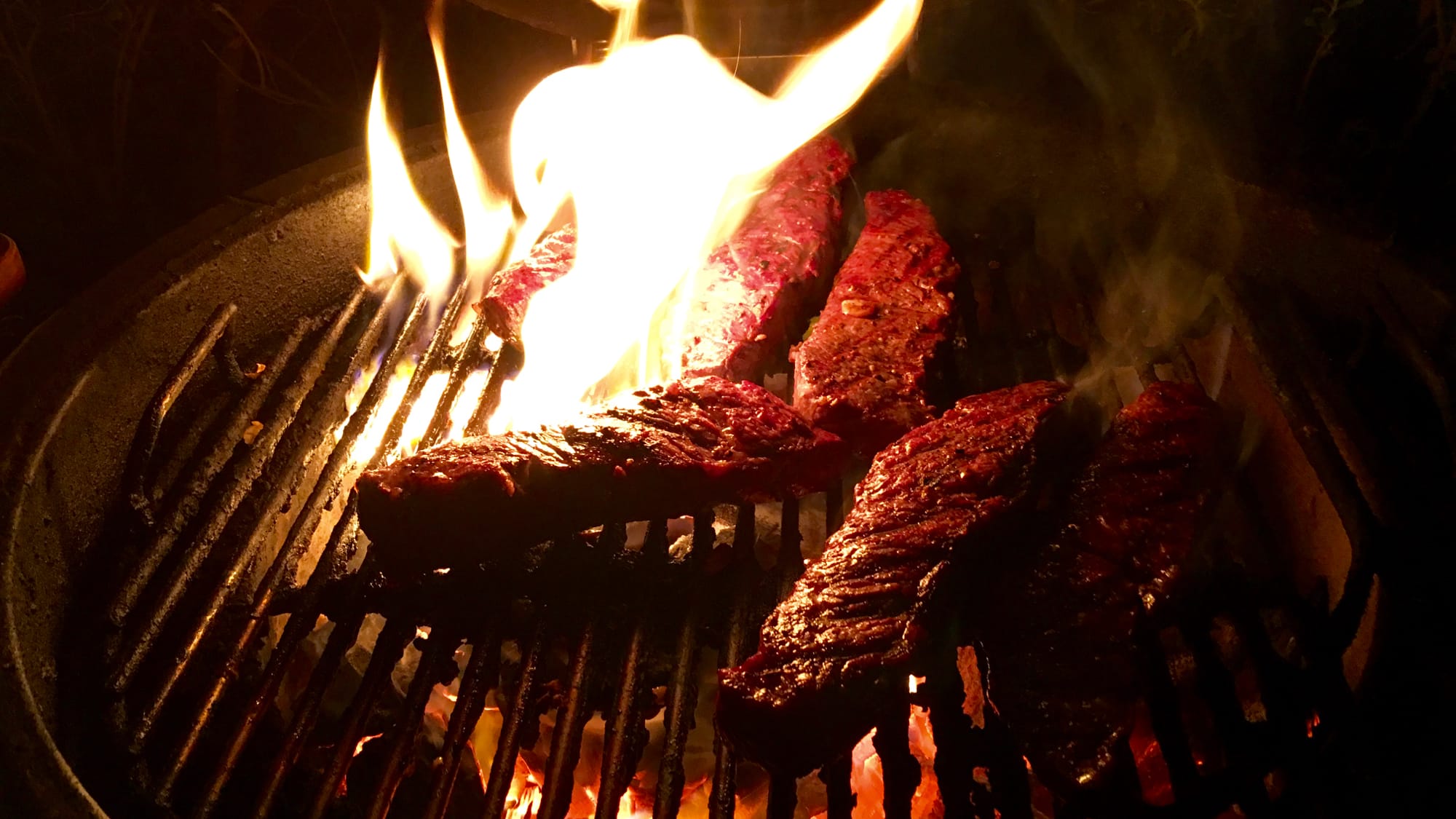 Steaks consumed by fire on a grill